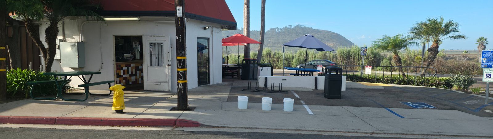 Three white buckets and a bike rack occupying a required parking space